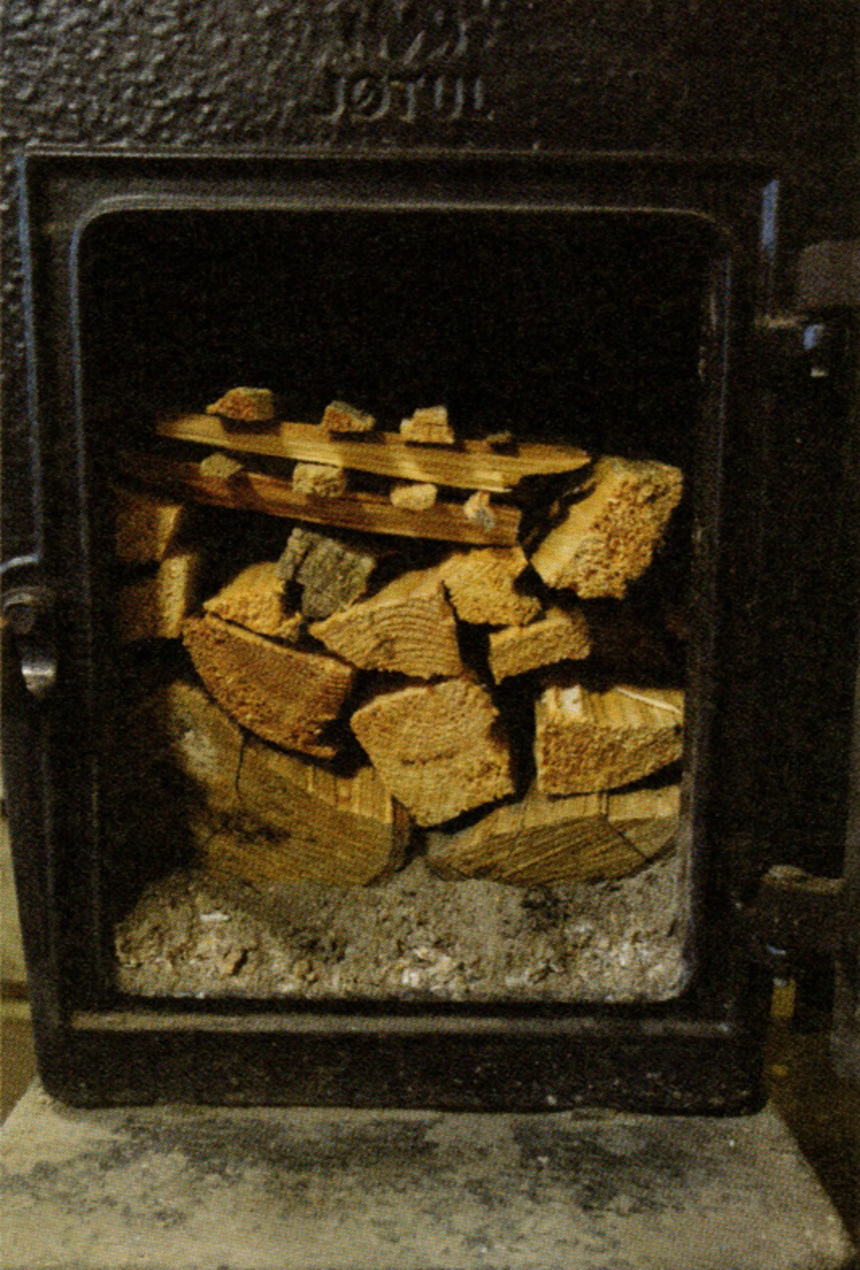 Dřevo je připraveno k zapálení, v topeništi je vrstva popela, která chrání před poškozením
