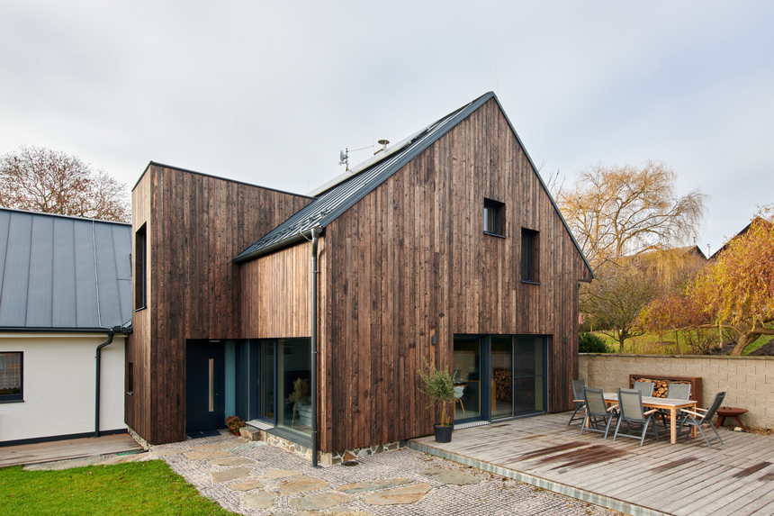 Původní část s bílou štukovou omítkou a novou přístavbu s fasádou z opalovaného dřeva sjednocuje moderní minimalistická krytina SATJAM Rapid.