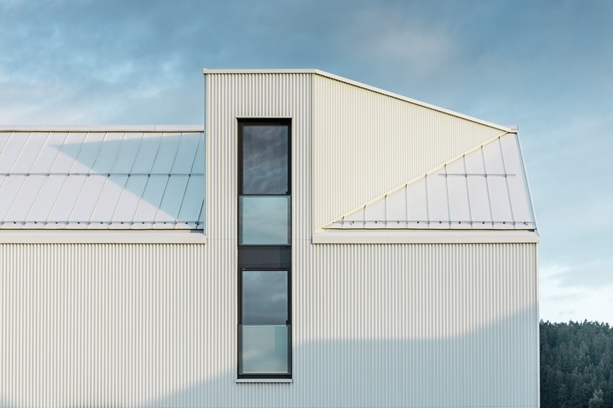Detailní pohled na bílý hliníkový vikýř a čisté linie fasády bez přesahů.