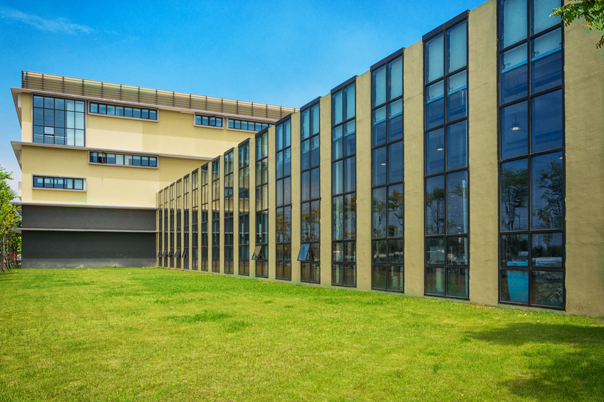 Moderní úsporná veřejná budova s velkoplošným zasklením a zateplenou fasádou.